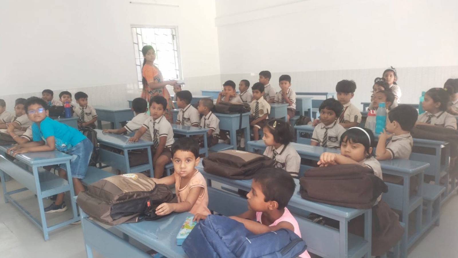 Bambini in uniforme scolastica seduti ai banchi durante una lezione