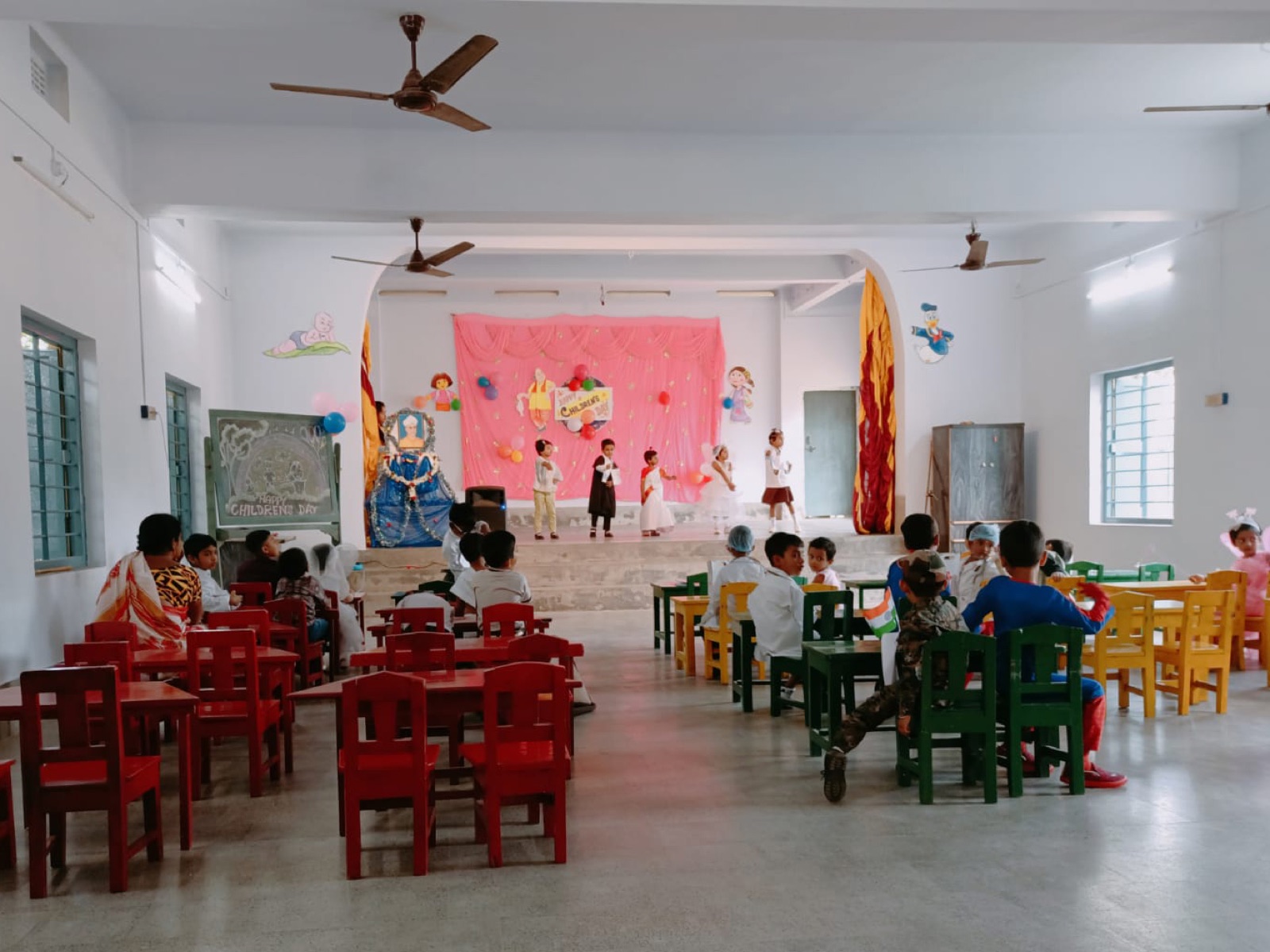 Bambini che si esibiscono su un piccolo palco decorato durante una recita scolastica